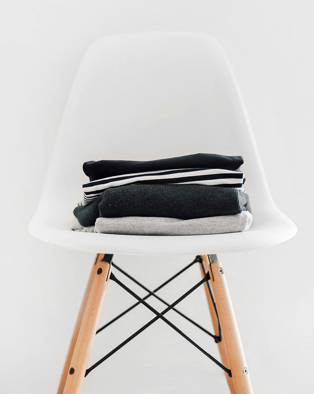 Ropa oscura doblada y colocada encima de una silla Ropa oscura doblada y colocada encima de una silla